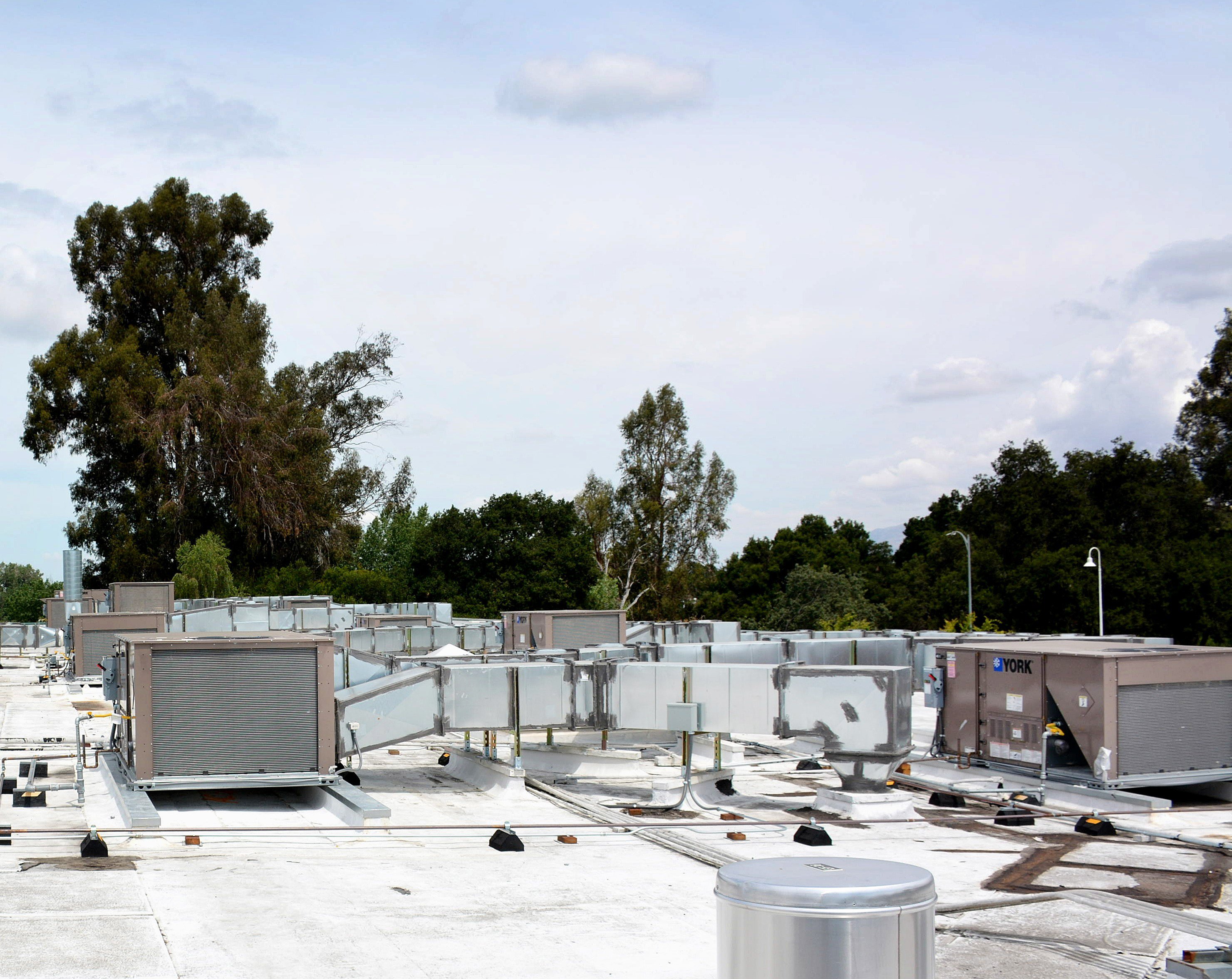Rooftop HVAC infrastructure and ductwork at an institutional facility undergoing modernization and renewal.