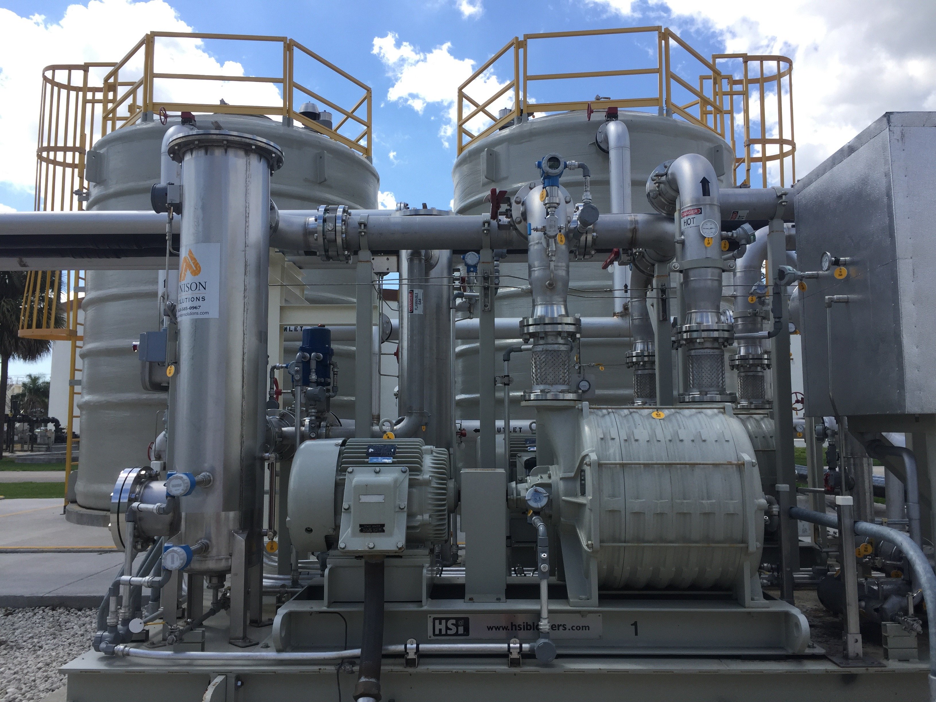 Industrial central utility plant equipment with pumps, piping, tanks, and process infrastructure at a wastewater treatment facility.