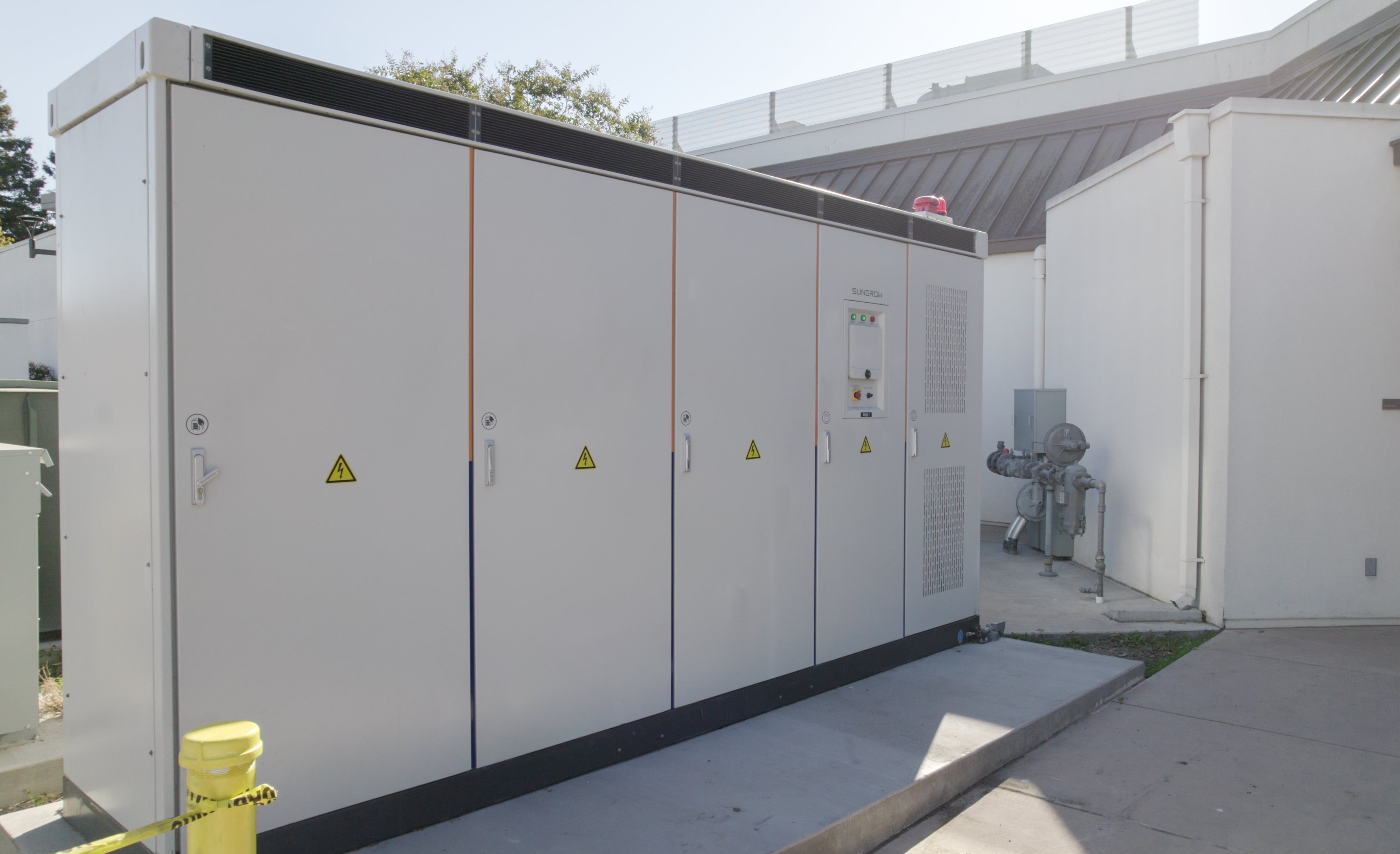 Microgrid electrical equipment cabinets with hazard labels installed outdoors at the City of Milpitas.