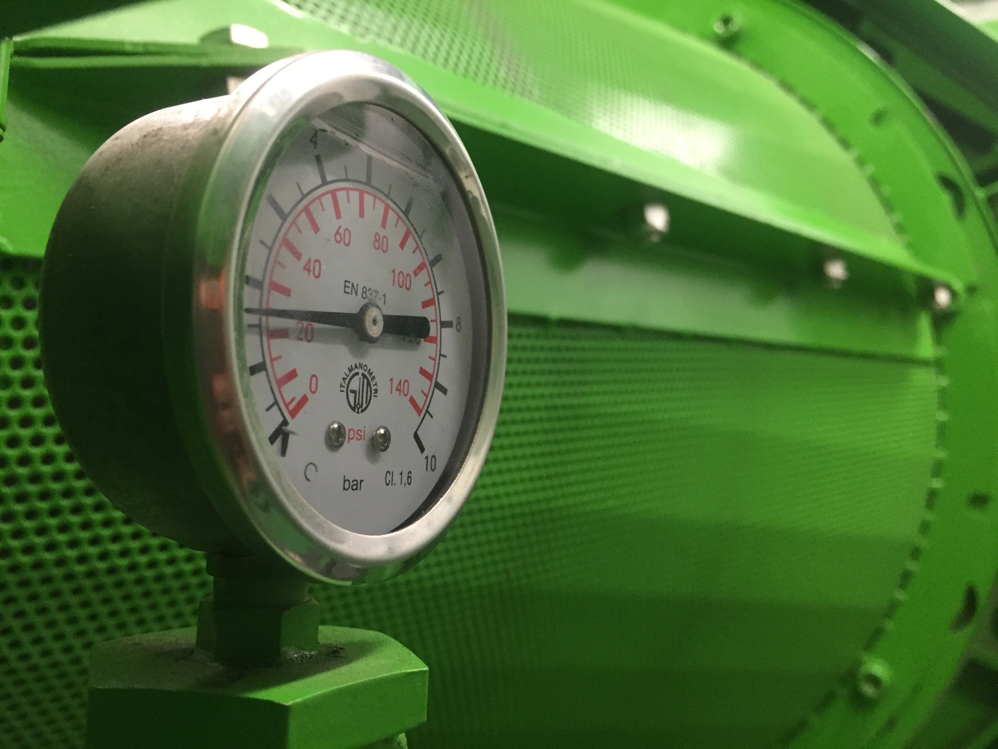 Close-up of an industrial pressure gauge and monitoring instrumentation on facility equipment.