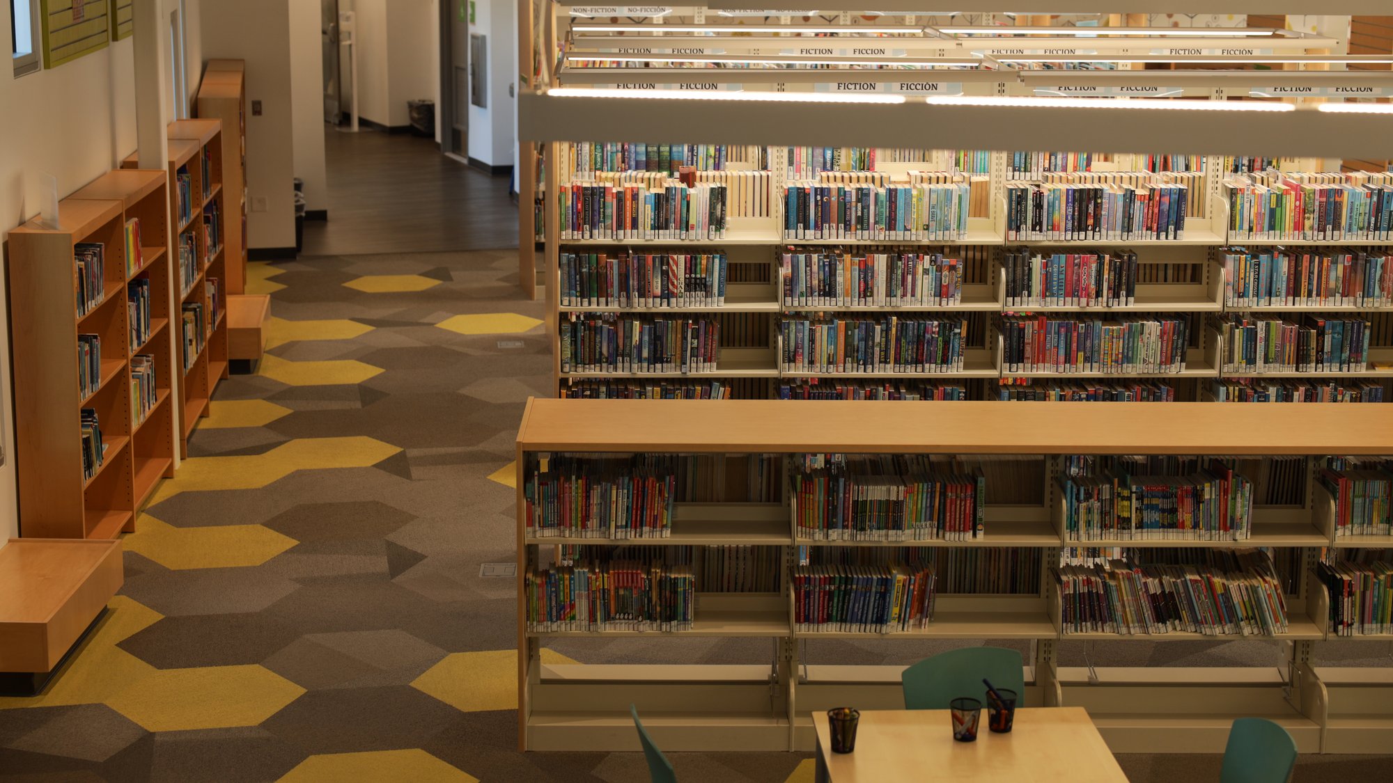 Interior view of a Mountain View Whisman USD school library featuring shelves of donated STEM books, reading tables, and a bright, modern learning space.