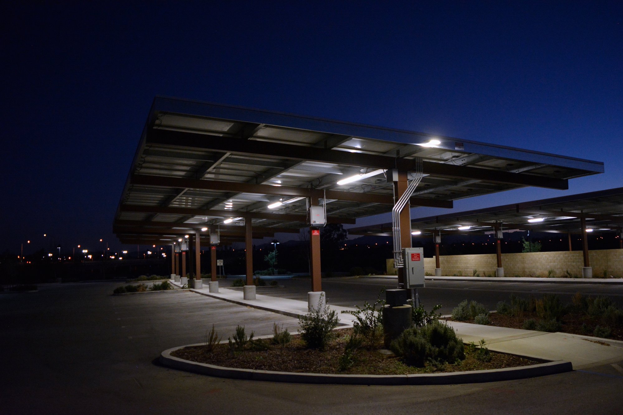 Solar carport structures illuminated at night at the Western Riverside County Animal Shelter, providing covered parking and integrated energy infrastructure.