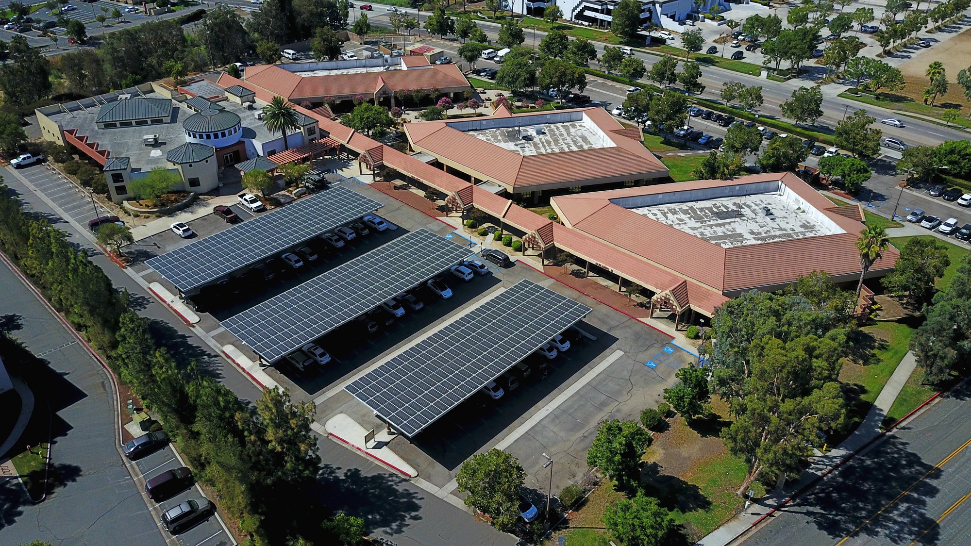 Aerial view of the Riverside County Temecula Administrative Center with solar carport canopies installed over parking areas, providing on-site renewable energy and shaded parking.