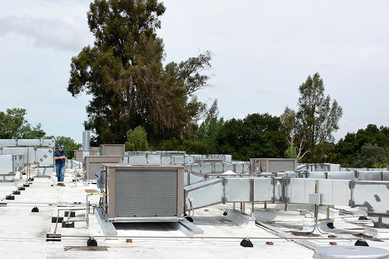 Rooftop HVAC infrastructure and ductwork at an institutional facility undergoing modernization and renewal.