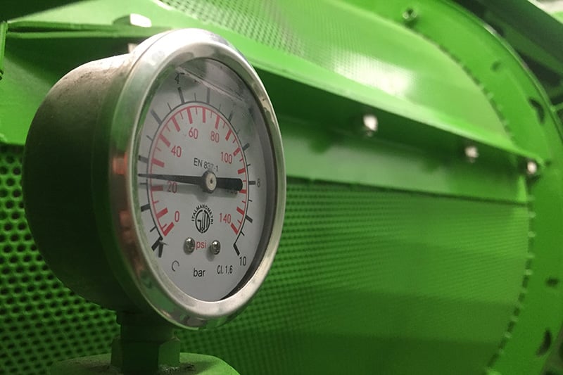 Close-up of an industrial pressure gauge and monitoring instrumentation on facility equipment.