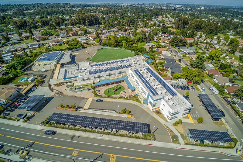 Aerial view of Hayward Unified School District’s Fairview campus featuring onsite solar energy infrastructure and parking lot solar canopies.
