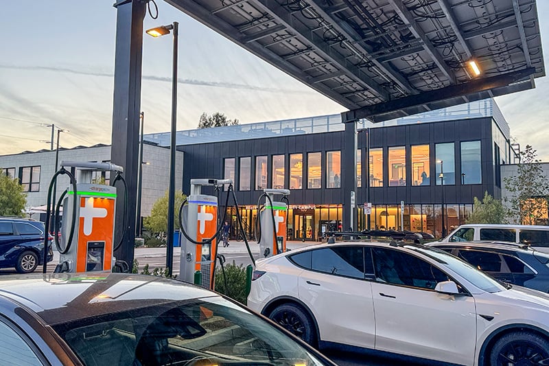 Solar carport canopy with integrated EV chargers charging parked electric cars at a City of Menlo Park community center.