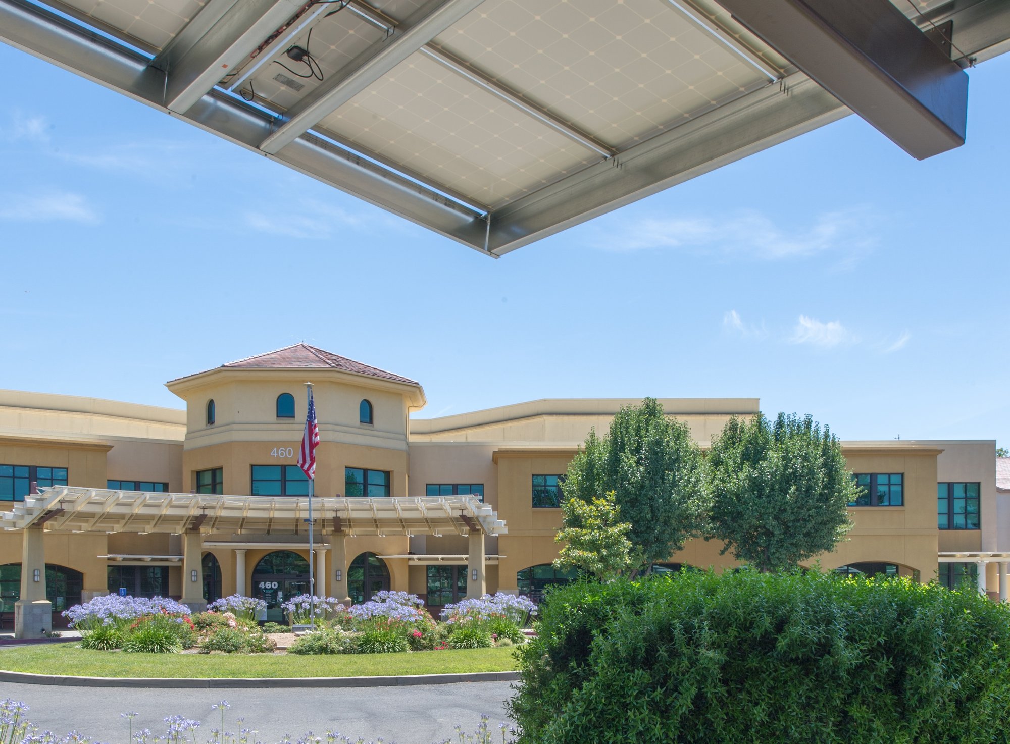 Solar canopy installation at a healthcare facility entrance, providing renewable energy while shading the drop-off area and maintaining uninterrupted access for patients and staff.